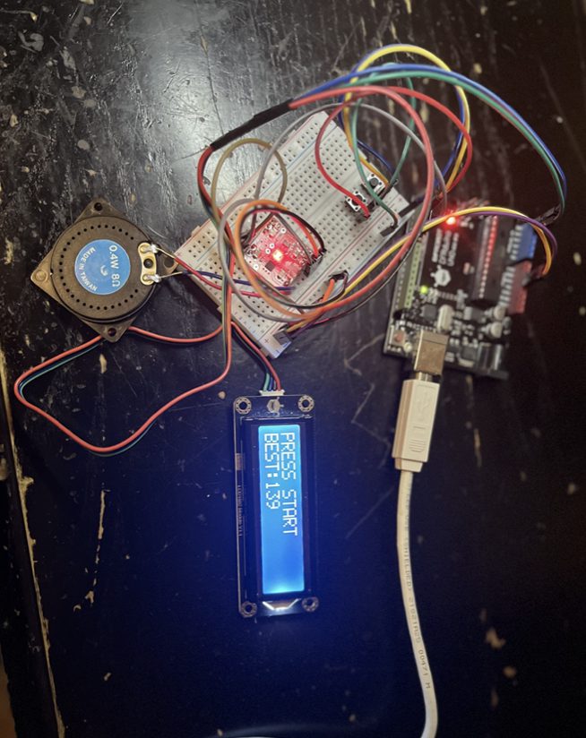 Overhead view of the breadboard, piezo buzzer, microcontroller and LCD showing PRESS START.